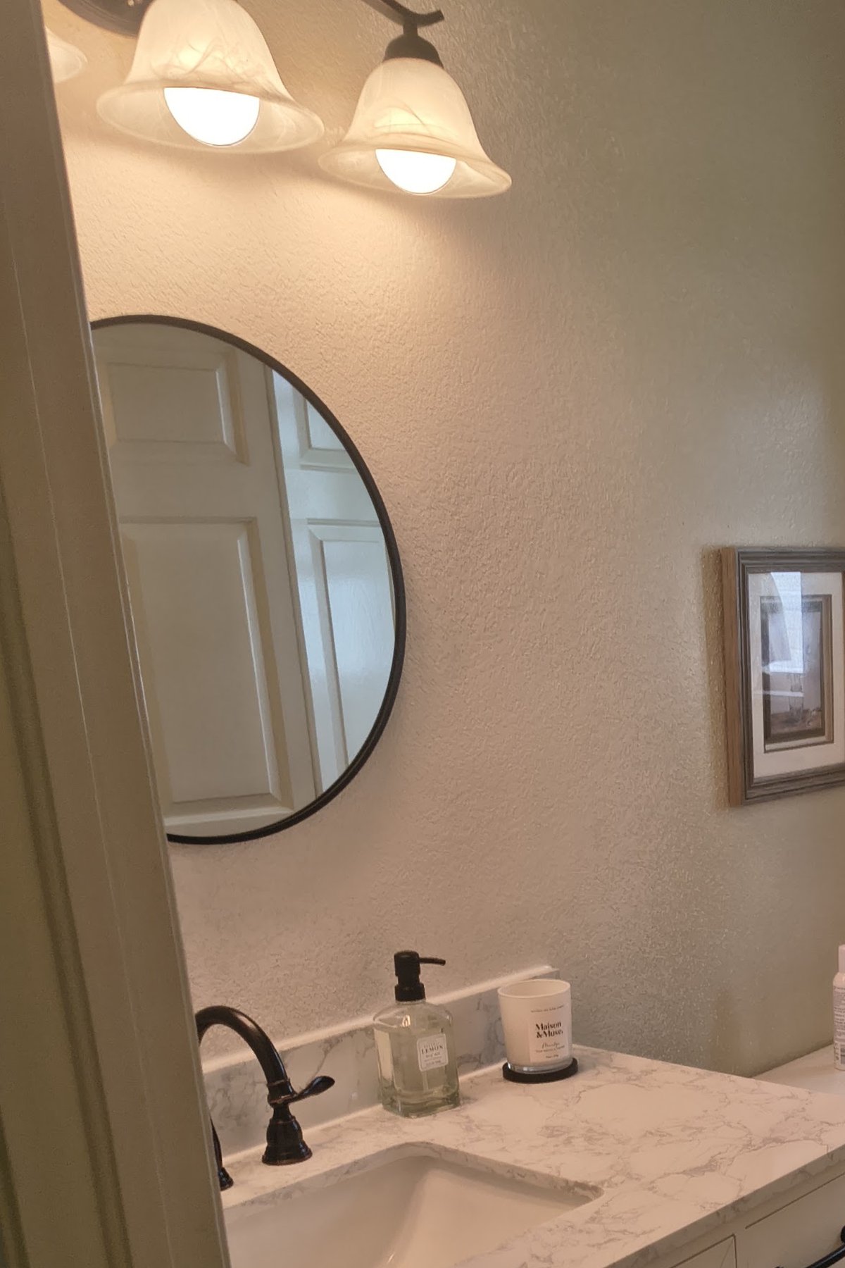 The bathroom we upgraded: white vanity and round mirror. This work was happening anyway.
