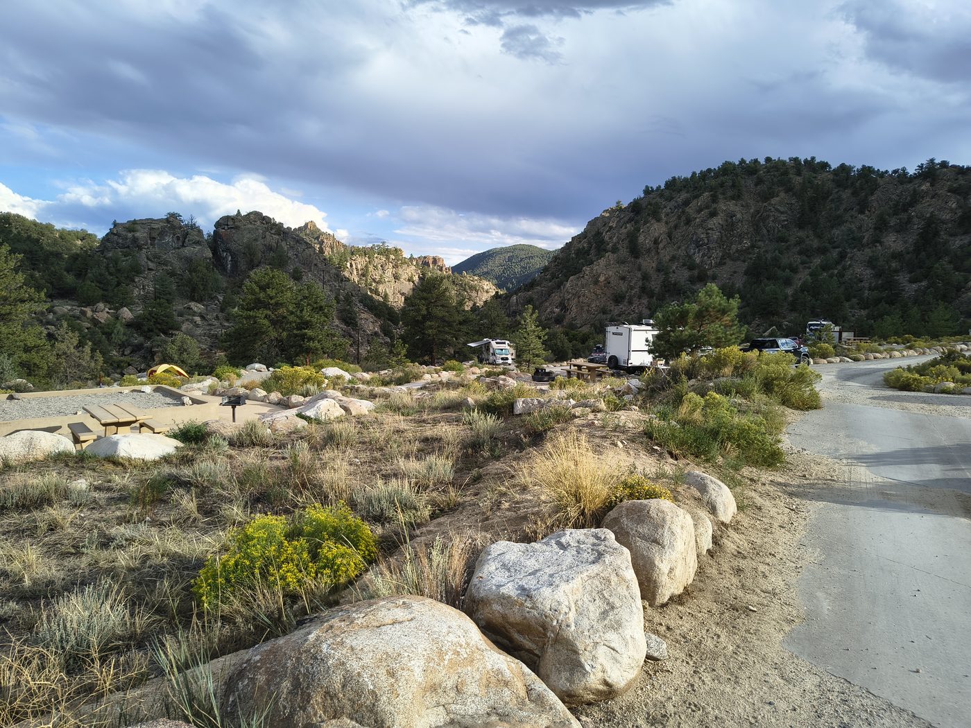 Hecla Junction campground with tents, RVs, picnic table, and canyon walls
